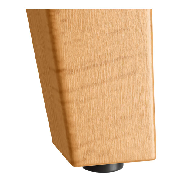 A Lancaster Table & Seating bar height table with a wood trestle base and honey maple finish.