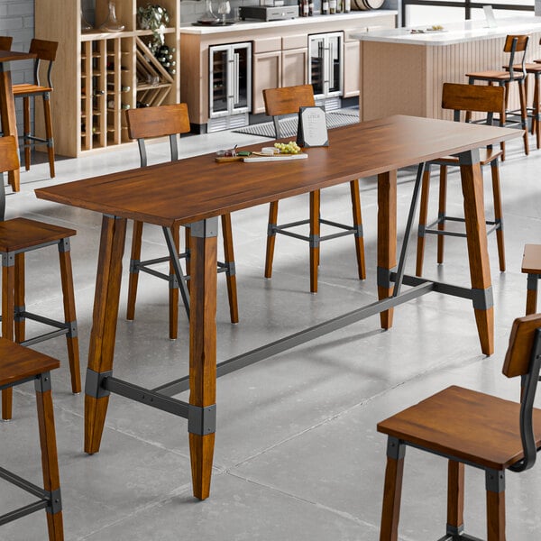 A Lancaster Table & Seating live edge wood bar height table with a plate and chairs.