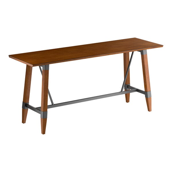 A rectangular bar-height table with a solid wood top in a walnut finish and angled wooden legs connected by gray metal supports.