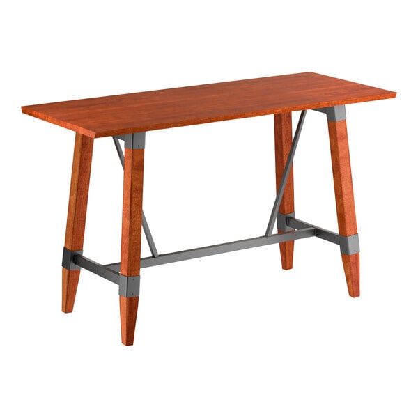 A rectangular bar-height table with a solid wood top and legs in a warm mahogany finish, featuring gray metal support brackets and crossbars for added stability.