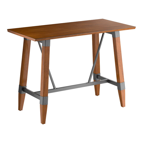 A rectangular bar-height table with a solid wood top and angled wooden legs connected by metal supports, featuring a rustic walnut finish.