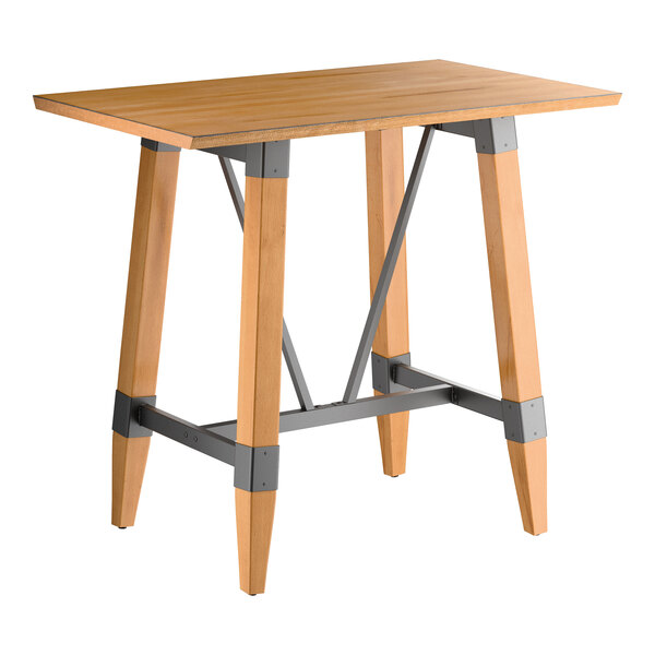 A rectangular bar-height table with a honey maple finish, featuring a solid wood top and angled legs connected by metal supports.