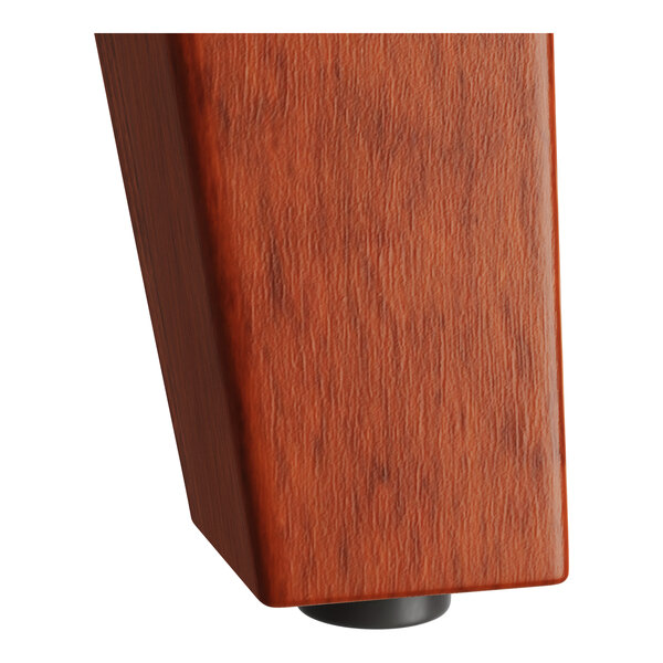 The trestle base of a Lancaster Table & Seating solid wood table with a rustic mahogany finish.