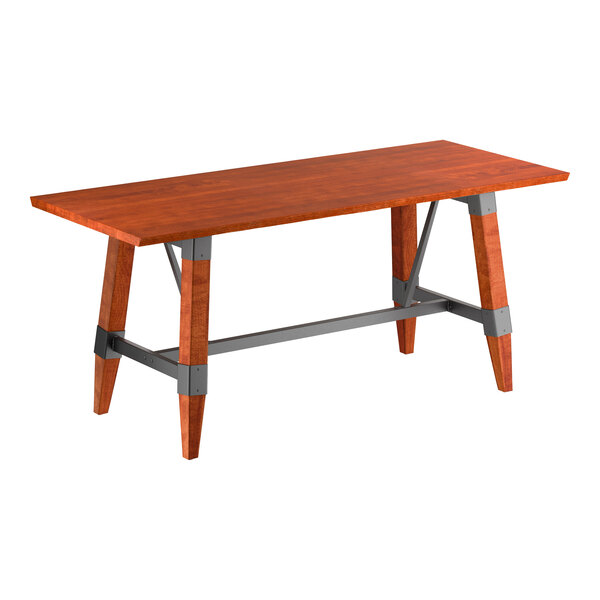 A rectangular wooden table with a reddish-brown finish, angled legs, and gray metal supports connecting the legs.
