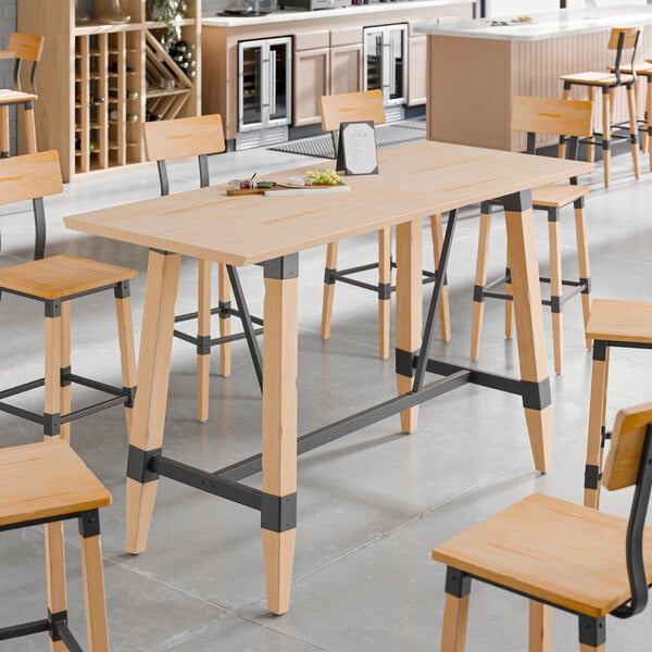 A Lancaster Table & Seating solid wood live edge bar height table with a plate on it.