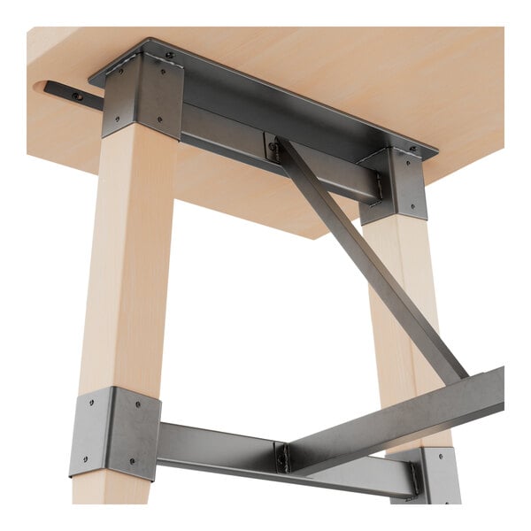 A bar height trestle base table with a solid wood live edge top and bleached oak finish, featuring metal supports and hardware.