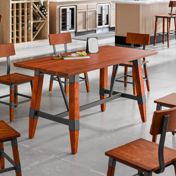 A rectangular solid wood live edge table with a rustic mahogany finish and a trestle base, surrounded by matching chairs in a modern dining setting.