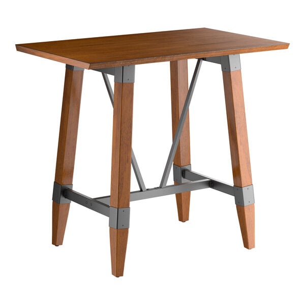 A rectangular bar-height table with a solid wood top and angled wooden legs connected by metal supports, featuring a rustic walnut finish.