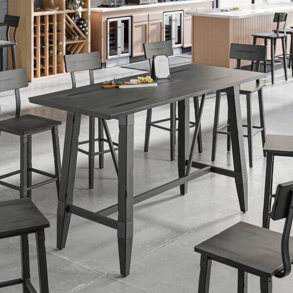 A Lancaster Table & Seating bar height table with a trestle base and chairs.