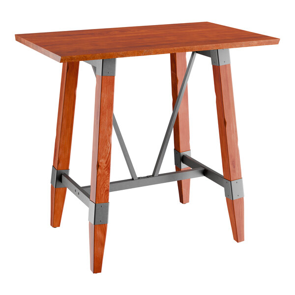 A Lancaster Table & Seating bar height wooden table with a live edge wood top and trestle base.