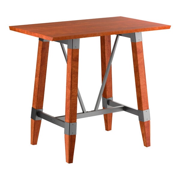 A rectangular bar-height table with a solid wood top and legs, featuring a rustic mahogany finish and metal support accents.