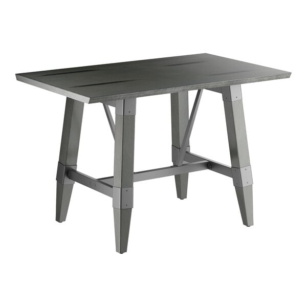 A rectangular table with a solid wood top and trestle base, featuring a slate gray finish and angled legs with metal supports.