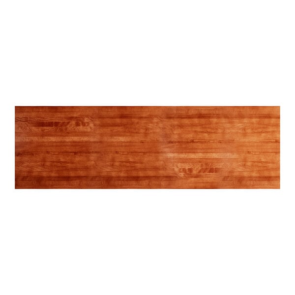 A long, rectangular solid wood table top with a rustic mahogany finish and a live edge design.