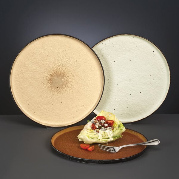 A Libbey white speckled stone tray with a fork and salad on it.