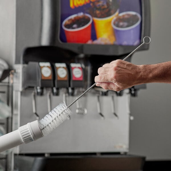 A hand holding a Carlisle medium duty pipe brush.
