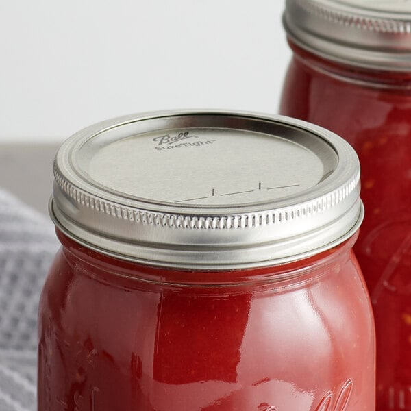 Ball Wide Mouth canning jar lid and band on a jar of red sauce.