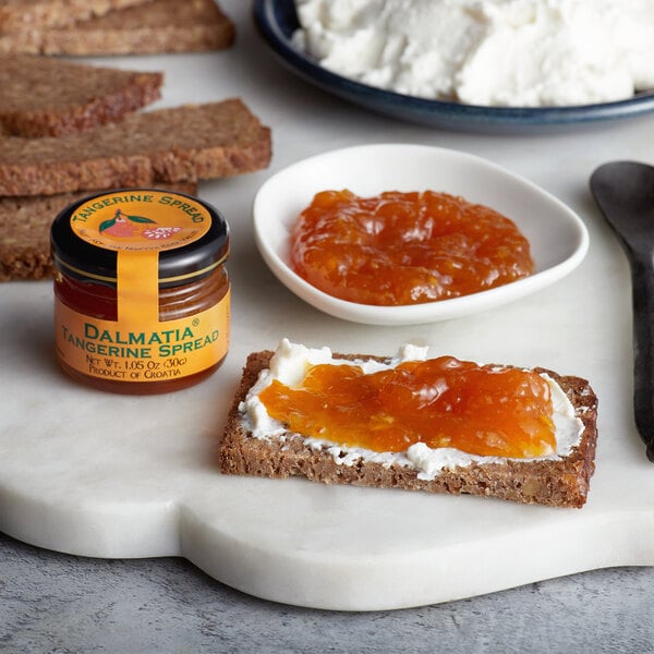 A plate with bread, cheese, and Dalmatia Tangerine Spread on it.