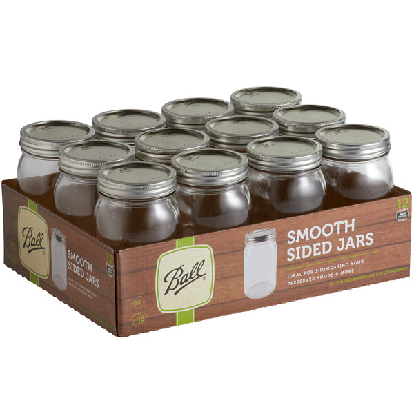 A box of Ball wide mouth glass canning jars with silver metal lids.