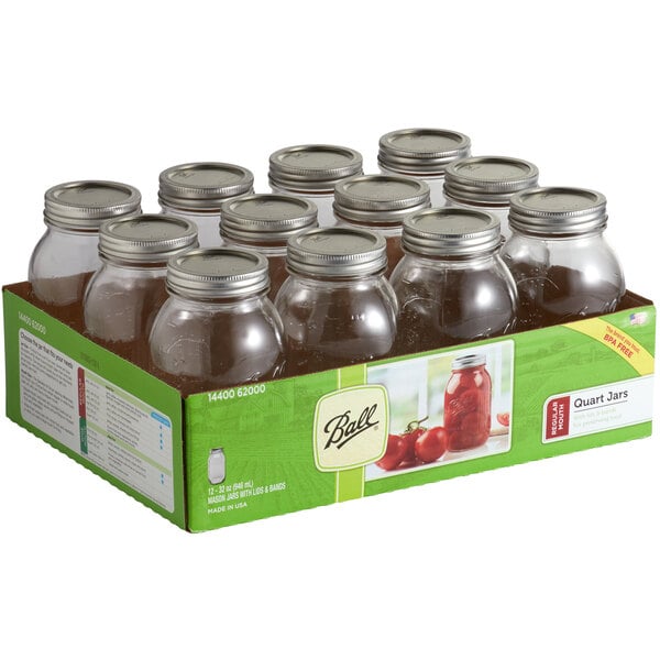 A box of twelve Ball glass canning jars with silver metal lids.