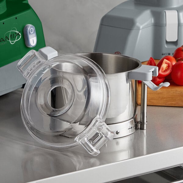 A stainless steel AvaMix bowl with an "S" blade in a machine on a counter.