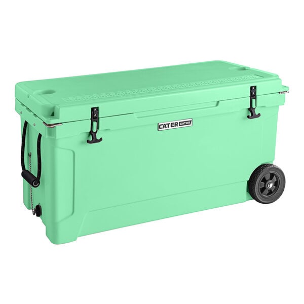 A seafoam green CaterGator outdoor cooler with wheels and black handles.