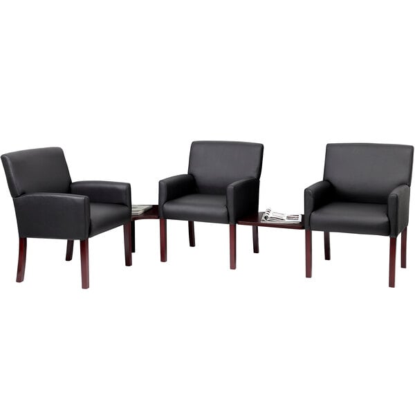 a black leather chair with wooden legs