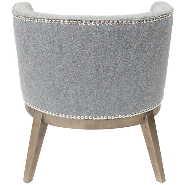 A medium gray Ava accent chair with wooden legs and gold studs.