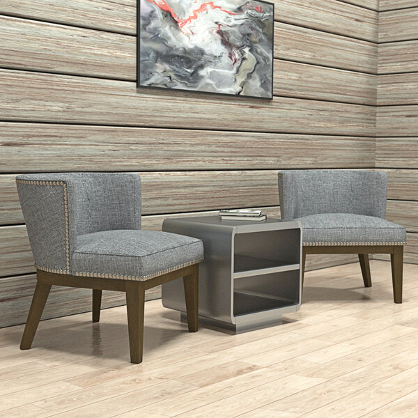 Two Boss Ava medium gray accent chairs with wooden legs next to a table in a lounge area.