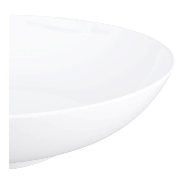 A partial view of a large, smooth, white, shallow bowl with a glossy finish.
