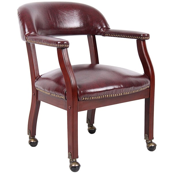 A Boss burgundy vinyl Captain's chair with casters.