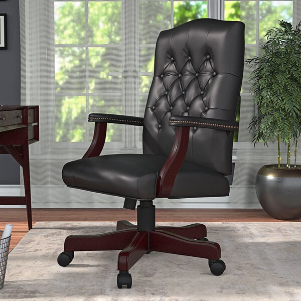 A Boss black leather office chair with a wooden base.