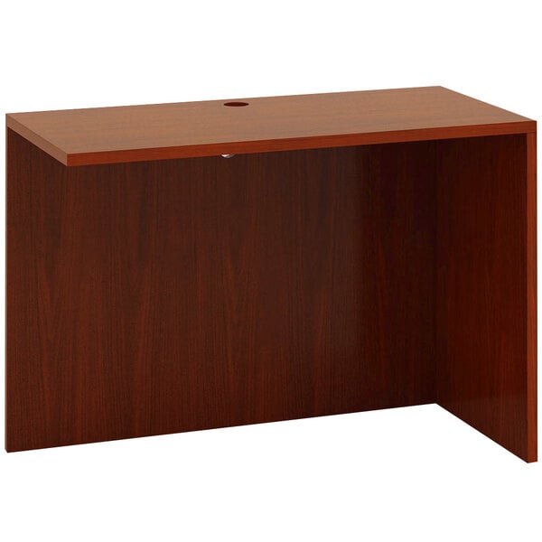 A cherry wood Boss reversible return desk with a hole.