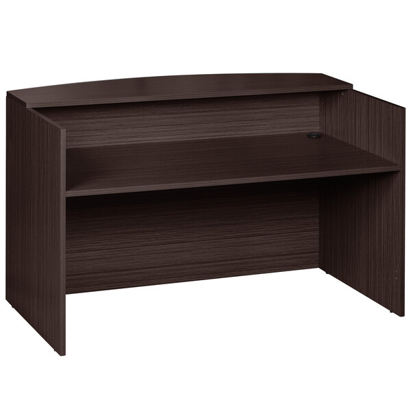 A brown laminate reception desk with a shelf on top.