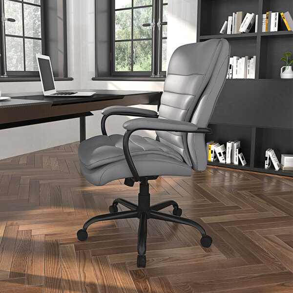 A gray Boss office chair in front of a desk with a laptop on it.