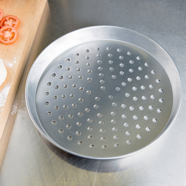 An American Metalcraft aluminum pizza pan with holes in it.