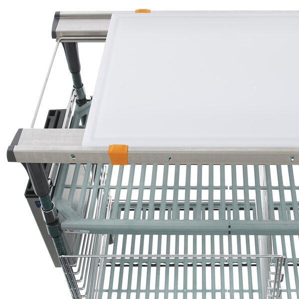 A metal cart with a white shelf and white accessories on top.