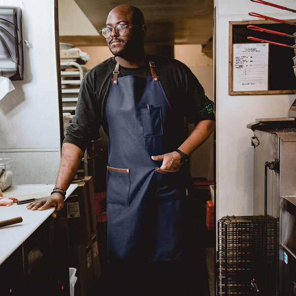 A man wearing a Hardmill navy canvas apron.