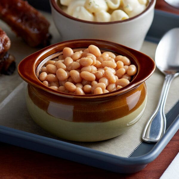 A bowl of Bella Vista pork and beans with a spoon.