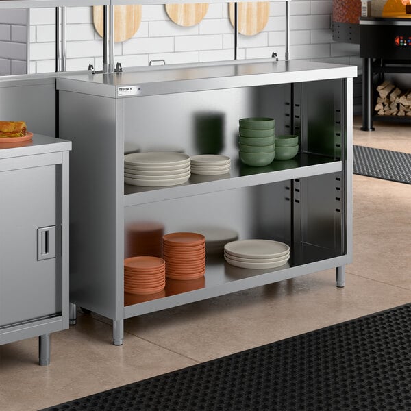 A stainless steel dish cabinet with an adjustable midshelf, holding various plates and bowls.