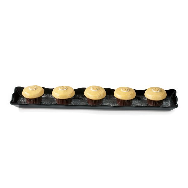 A black rectangular melamine display tray with four cupcakes on it.