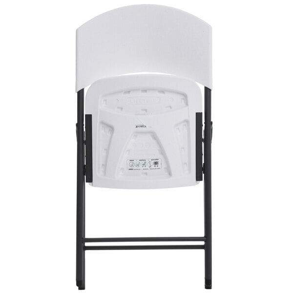 The back of a white Lifetime Light Duty folding chair with black legs.