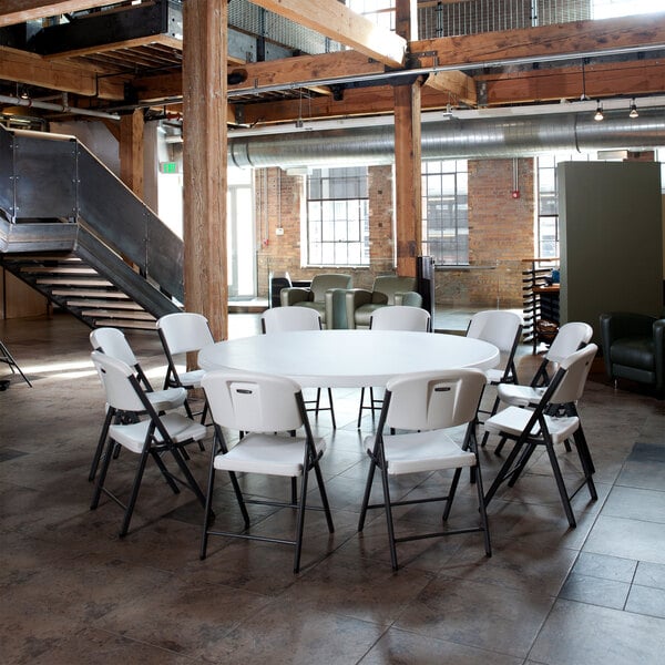 A stack of white Lifetime Classic folding chairs.