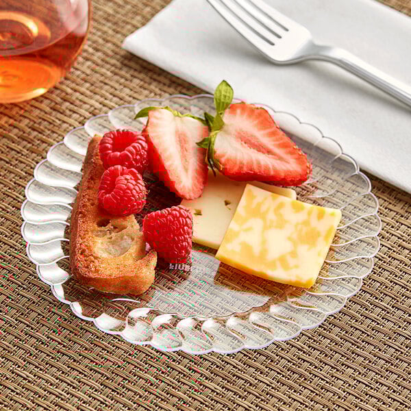 A Fineline clear plastic plate with cheese, strawberries, and crackers.