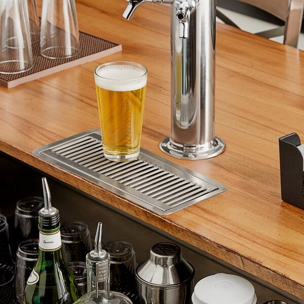 A Regency stainless steel flush mount beer drip tray on a bar counter.