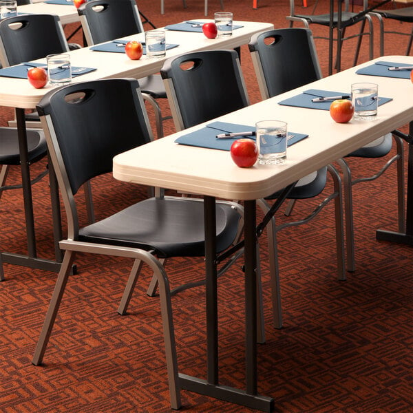 A row of black Lifetime stacking chairs.