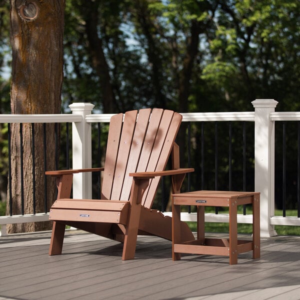 A brown wooden Adirondack table on a deck.