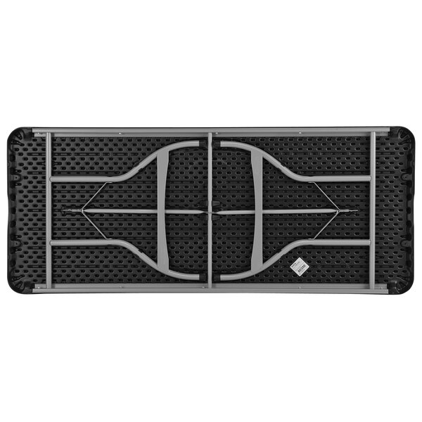 A black and grey Lifetime plastic folding table with two holes in it.