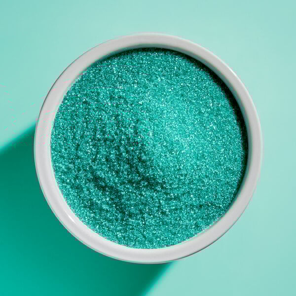 A bowl filled with fine light green sanding sugar.