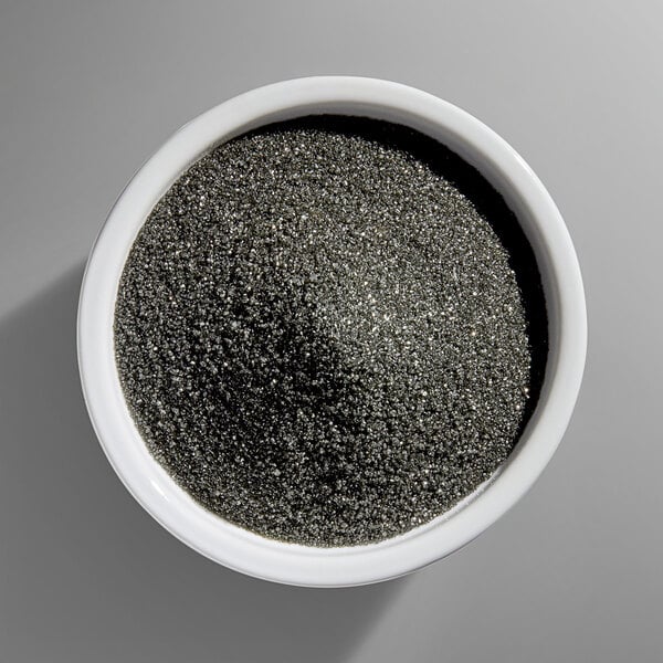 A white bowl filled with fine black sanding sugar.