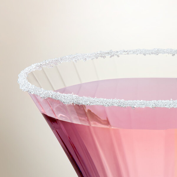 A glass of pink liquid with a white Adourne Clear Sanding Sugar rim.
